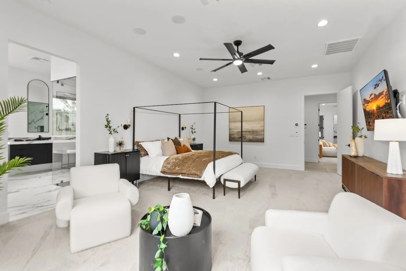 A staged bedroom with a canopy bed and seating area