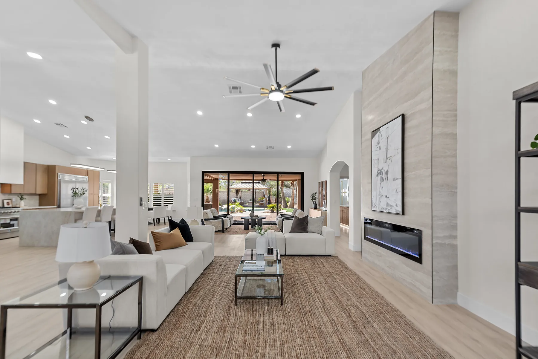 A staged open-plan living room, wide and light-filled